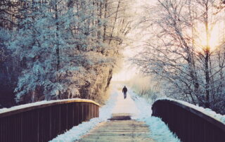 Man som går över snöig bro